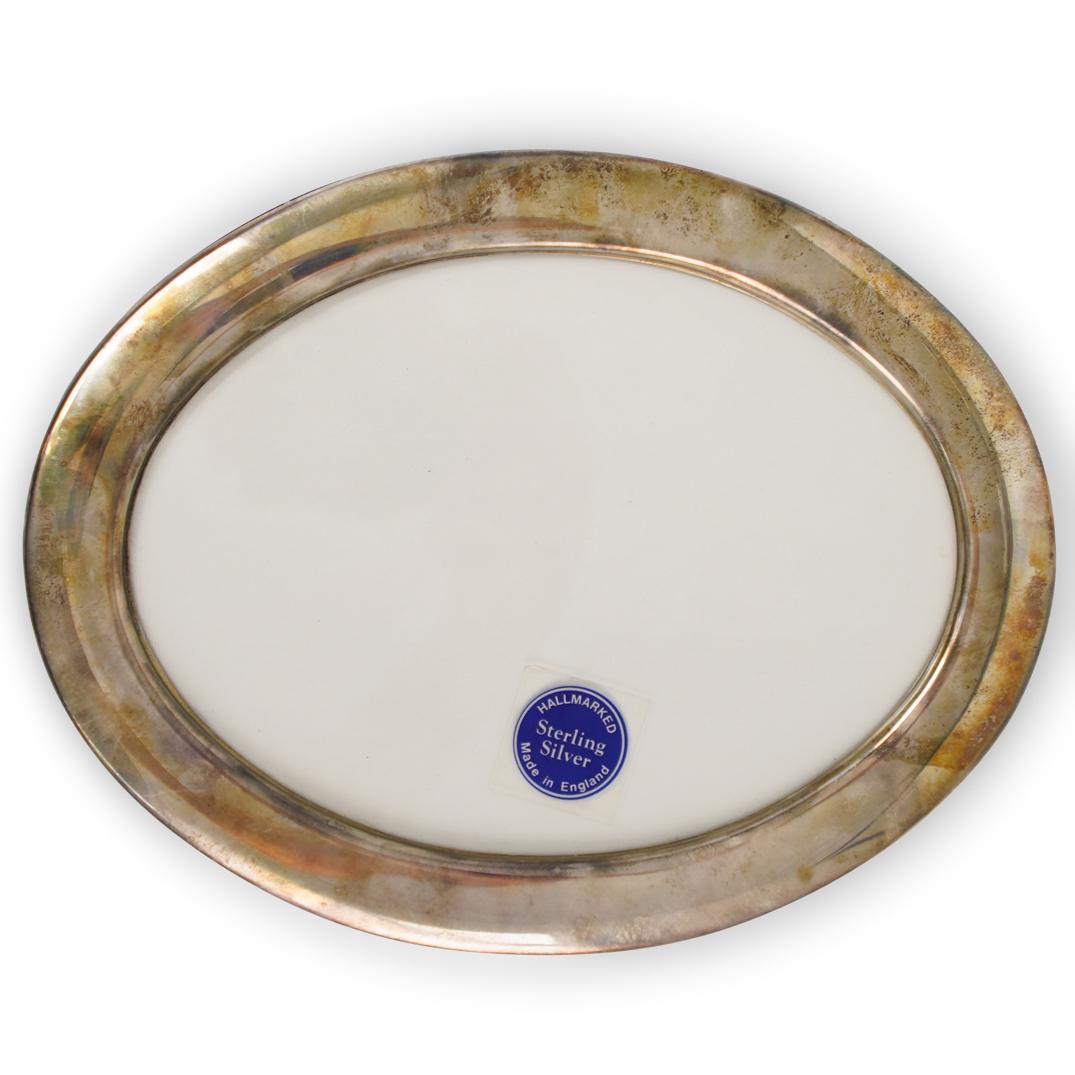 Sheffield Silver Picture Frame: DESCRIPTION: A Sheffield silver oval picture frame, hallmarked with R. Carr stamp. CIRCA: 20th Century ORIGIN: London DIMENSIONS: L. 8.75" x W. 6.75" CONDITION: Great condition. See lot description fo