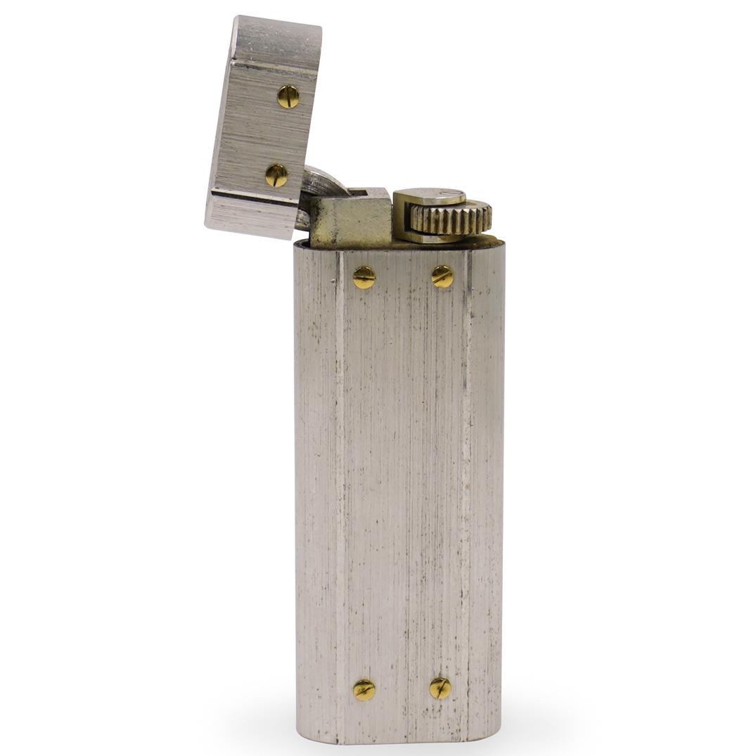 Cartier Santos Stainless Steel Lighter: DESCRIPTION: A Cartier "Santos" lighter composed of stainless steel with 18k gold screw accents. In working condition needs lighter fluid, marked along the bottom "Cartier Paris" with S# 92246V. With 