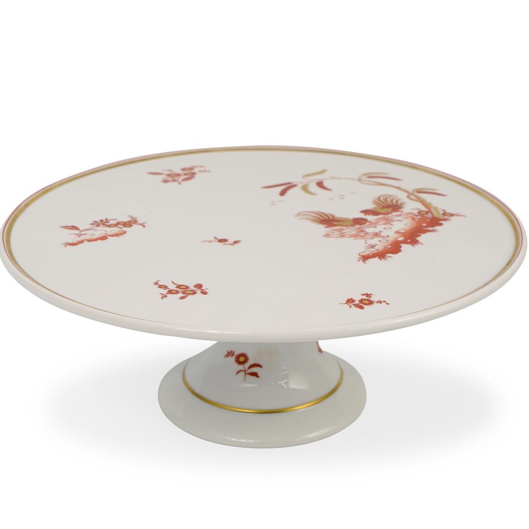 Richard Ginori Porcelain Cake Stand: DESCRIPTION: A Richard Ginori porcelain cake stand. Features a fluted base and stem supporting the top plate. Garnished with Oriental floral motifs and birds feeding. Finished with gilded accents and 