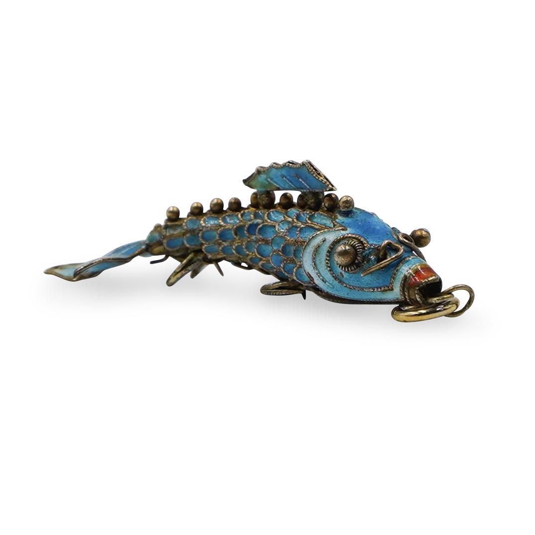 Silver Enamel Fish PendantÃ‚: DESCRIPTION:Silver Enamel Fish Pendant features a mechanical design. Blue and white hues throughout. Total Weight: 6.4 grams CIRCA: 20th Ct DIMENSIONS: 2.25" CONDITION: Great condition. See lot descri