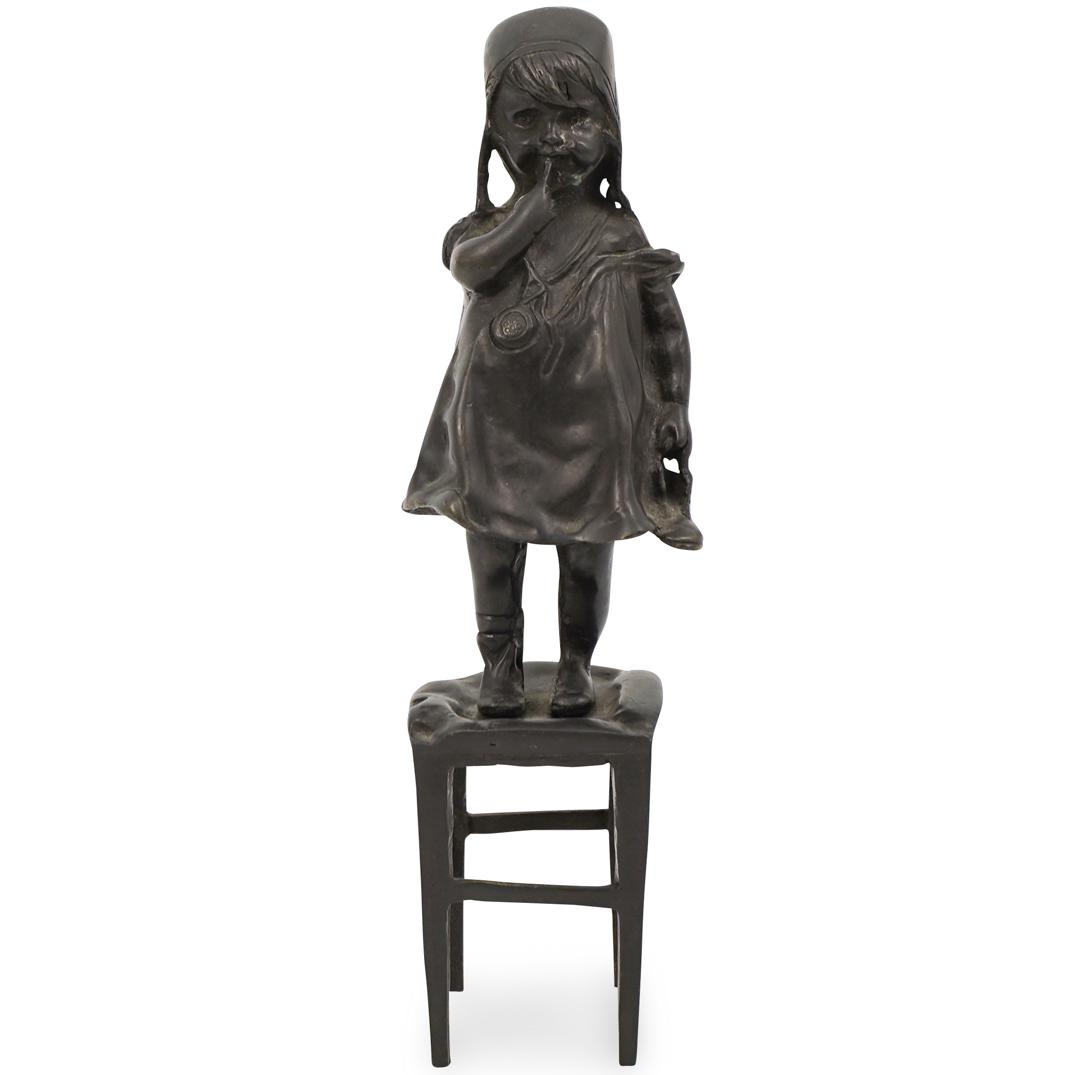 After Juan Clara Bronze Sculpture: DESCRIPTION: A bronze sculpture of a young girl in the style of Juan Clara Ayats (Spanish, 1875-1958) depicts a young girl standing on a stool. CIRCA: 20thÃ‚ ORIGIN: SpainÃ‚ DIMENSIONS: H. 12" x