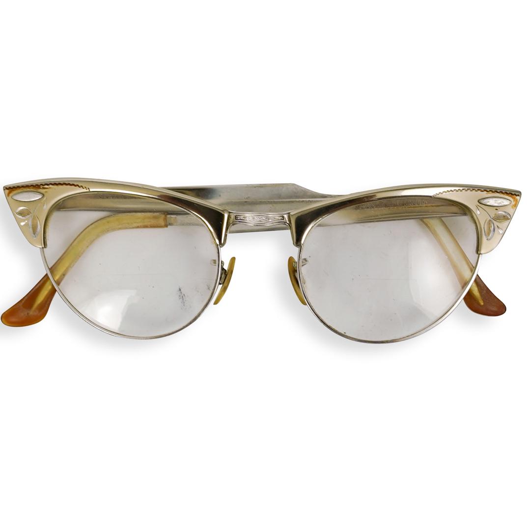 Vintage Gold Filled Aluminum Glasses: DESCRIPTION: A pair of vintage ladies reading glasses composed of gold filled aluminum. Marked on legs. CIRCA: 20th Century DIMENSIONS: L. 5" CONDITION: Good condition. See lot description for details