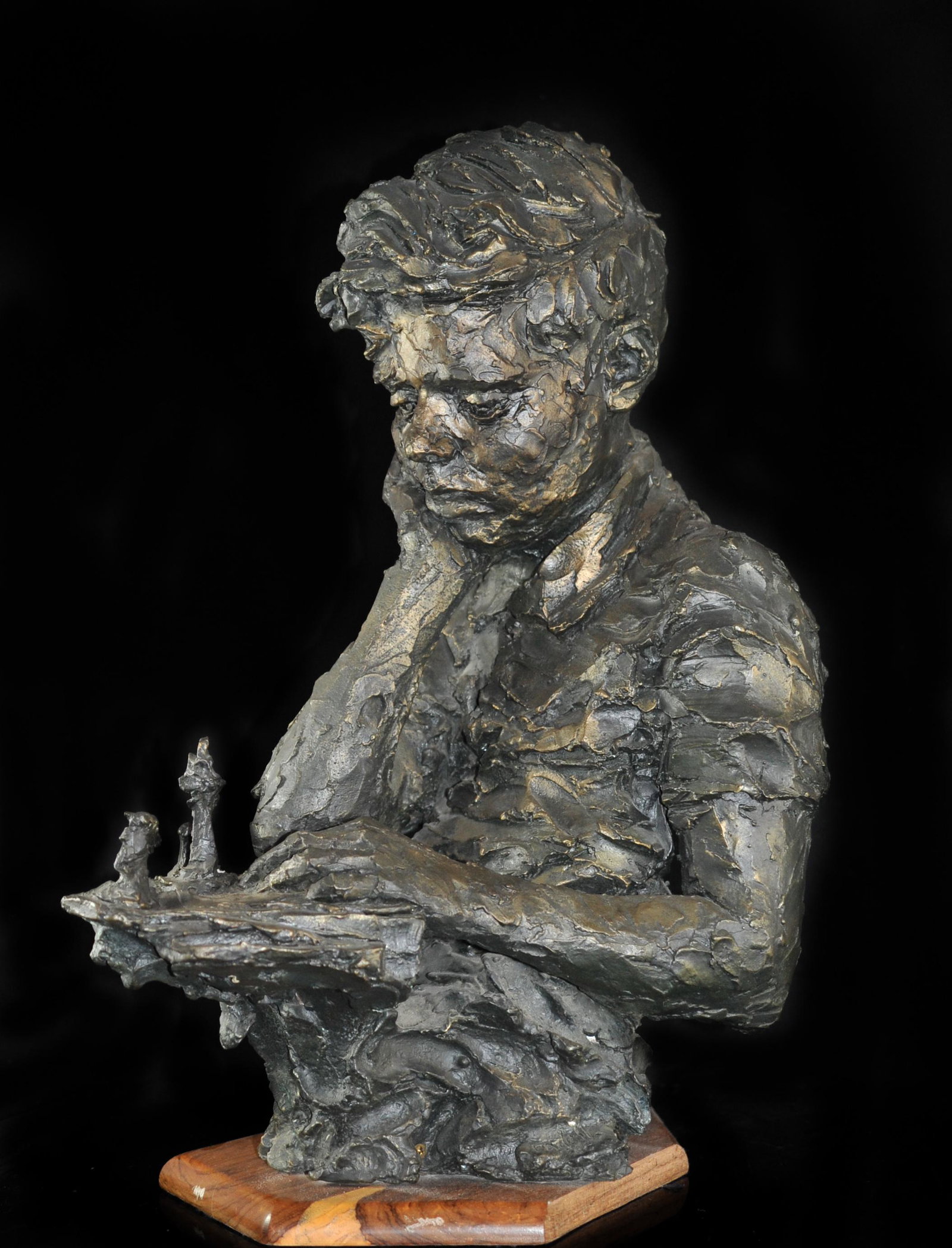 Signed Young John F. Kennedy Bronze: DESCRIPTION: A John F. Kennedy bronze featuring a young Kennedy pensive while playing chess. Bronze has unique texture with a beautiful patina. Signed what appears to be "Rauell 66". Standing on woode