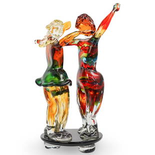 Signed Murano Art Glass Figural Group: DESCRIPTION: A Murano art glass figural group featured in a multicolored foundation, depicts a male and female figure dancing atop a black base. Signed indistinctly along the base.CIRCA: 20th