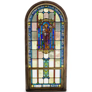 Cathedral Arched Stained Glass Window: DESCRIPTION: An arched stained glass church window. In two parts. Features colorful glass panels with a central image of St. Joseph holding Baby Jesus, on an arched wood frame. Originally displayed