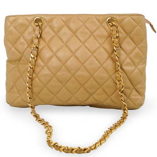 Chanel Beige Quilted Leather Shoulder Bag: DESCRIPTION: Tote bag with central compartments, top zip closure and interior pocket. Matching leather lining. Gold hardware. Labeled "Chanel" "Made in Italy" Includes dust bag.CIRCA: 1990sORIGIN: