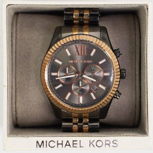 Michael Kors Stainless Ladies Watch: DESCRIPTION: A Michael Kors Ladies watch composed of stainless steel with a gold plated bezel and alternating links. Model MK-856, Comes with original box.CIRCA: 21st Cent.ORIGIN: USADIMENSIONS: