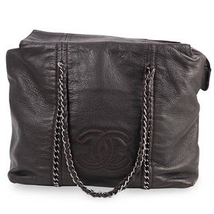 Limited Edition Chanel Leather Tote Bag: DESCRIPTION: A limited edition leather tote bag by Chanel, in a burgundy tone with stitched 'Cc' motif to front, silver metal hardware and chain leather weave strap. Stamped: Chanel. Includes