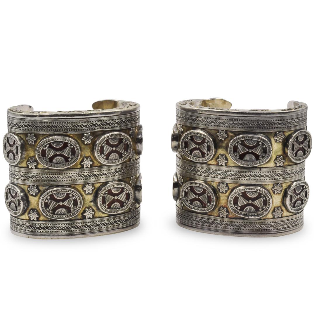 Pair of Oriental Sterling and Gold Inlay Cuff Bracelets: DESCRIPTION: A pair of mixed metal cuff bracelets. In a middle eastern motif composed of sterling and gold inlay with tinted glass accents. Total Weight: 312 Grams CIRCA: 20th Century ORIGIN: Middle E