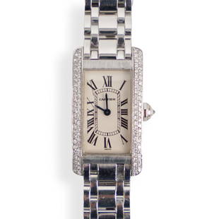 Cartier 18k and Diamond Tank Americaine Watch: DESCRIPTION: A Cartier Tank Americaine Ladies watch, comprised of 18k white gold casing and bracelet, hite dial, Roman numeral hour markers, diamond bezel, winder with a diamond, bracelet and folded