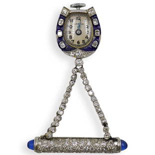 Art Deco Diamond and Enamel Clock Pin: DESCRIPTION: An Art Deco Clock Pin decrorated with single cut diamonds amounting to approx .7 ct, the Akron clock is hanging from two strands, completed by two sapphire cabochones on each side of the