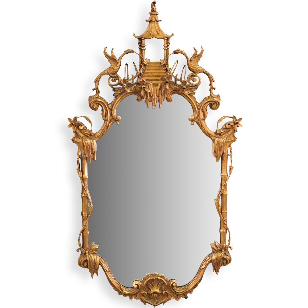 Carved Chinoiserie Gilt Wood Mirror: DESCRIPTION: A Carved Giltwood mirror executed in a Chinoiserie style, features bamboo stylized carvings along the sides, accented at the top with bird and floral patterns, completed with a shrine mot
