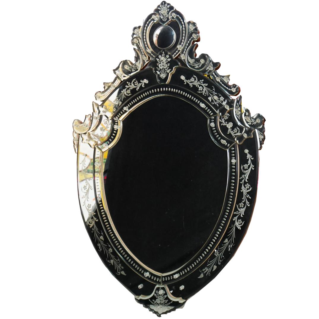 Venetian Etched Glass Mirror: DESCRIPTION: A Venetian mirror, embellished along the sides with etched floral motifs, Crafted from beveled glass, surrounded by an intricate border comprised of individual glass pieces in scrolling, 