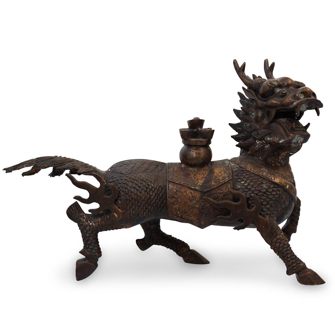 Chinese Qilin Bronze: DESCRIPTION: A cast bronze sculpture of mythical Qilin creature with head of a dragon and body of a horse, in a warm brown patina. CIRCA: 20th Century ORIGIN: China DIMENSIONS: H.15" x W. 24" x D. 5"�