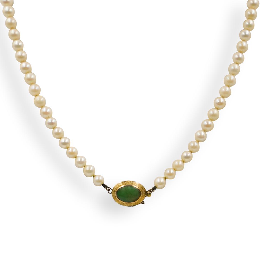 Jadeite and Beaded Pearl Necklace: DESCRIPTION: A Beaded Pearl necklace featuring a 14k yellow gold clasp, centered by a Jadeite cabochon. Marked along the clasp "14k HK" CIRCA: 20th Cent. ORIGIN: Hong Kong DIMENSIONS: L: 9" (Closed) C