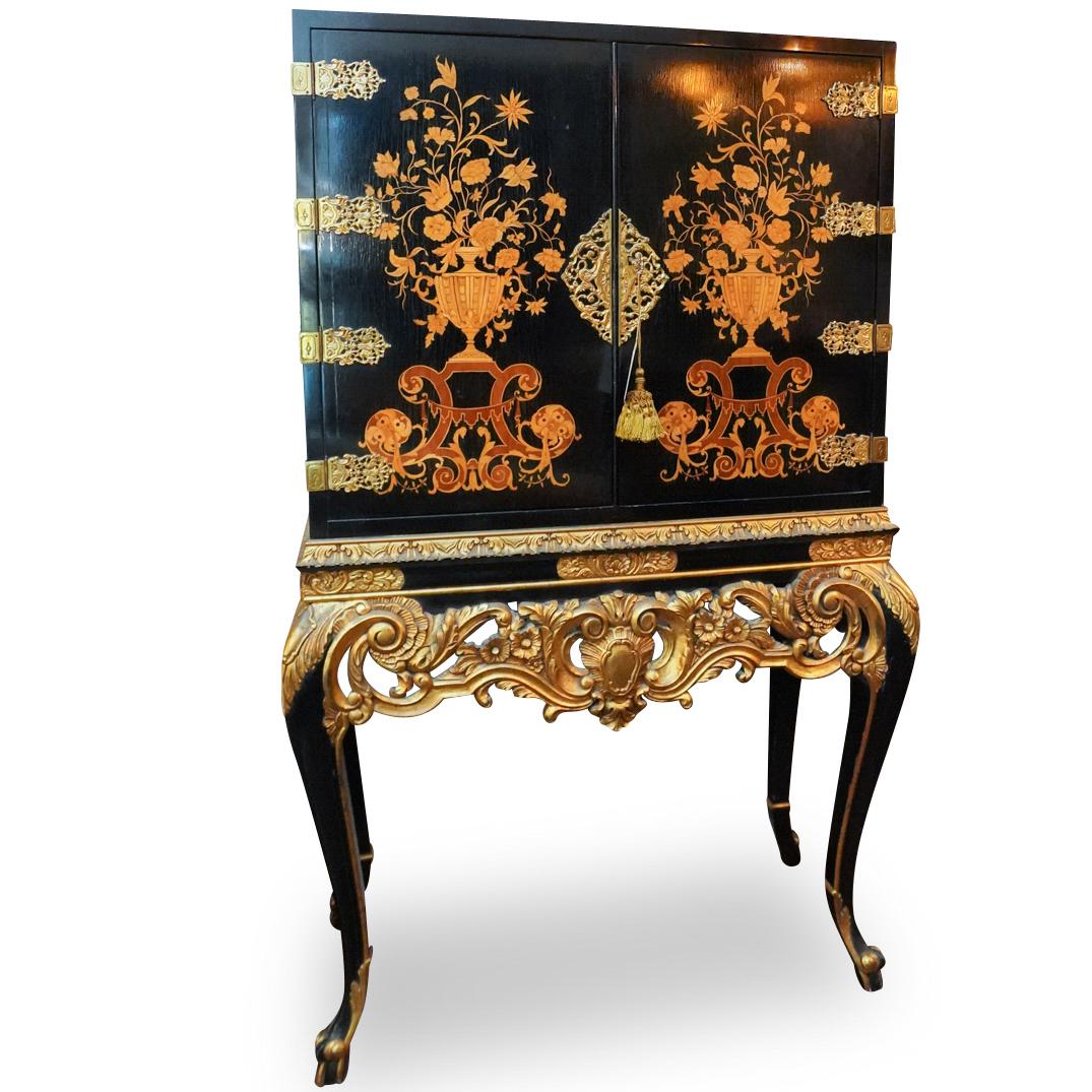 English Wooden Inlay and Lacquer Wood Cabinet: DESCRIPTION: A English Cabinet composed of a Lacquer body, further garnished by a giltwood skirt patterend with baroque motifs, and decorated at the center with wood inlay depicting floral vases. Comp