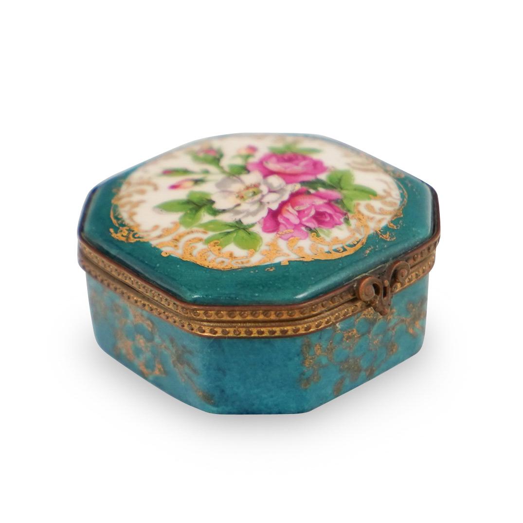 Limoges Porcelain Jewelry Box: DESCRIPTION: A Limoges hand painted porcelain jewelry box. Features painted colorful floral motifs along the lid over a blue and gilt decorated ground. Signed on the underside. CIRCA: 20th Century ORI