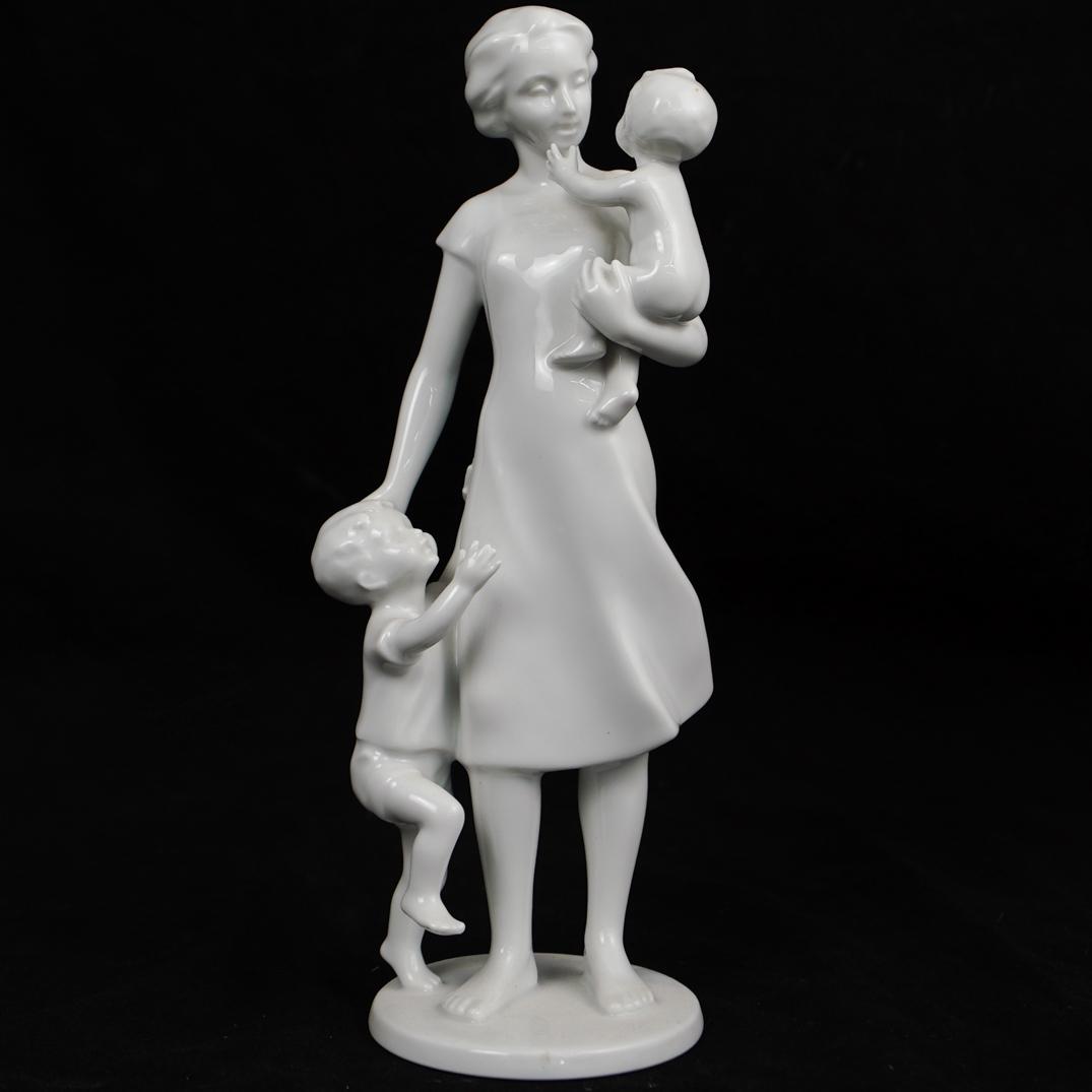 AK Kaiser Glazed Porcelain FigurineÃ‚: DESCRIPTION: An AK Kaiser glazed porcelain figurine featuring a woman and her children. Hallmarking in blue on bottom. CIRCA:Ã‚ ORIGIN: Germany DIMENSIONS:H:10" x D:3.25" (At base) CONDITION: Great