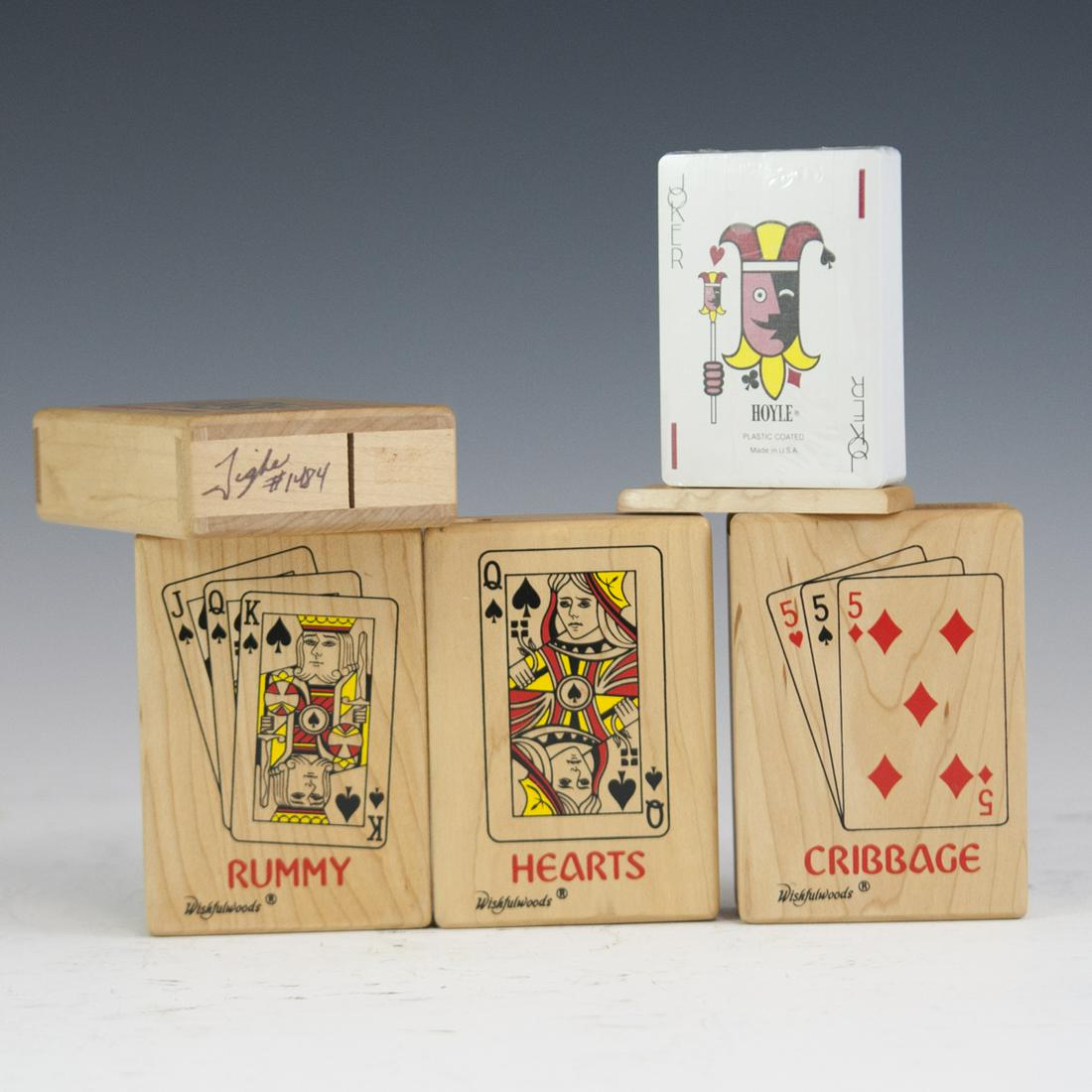 Signed Wishful Wood Playing Card Decks: DESCRIPTION: A set of four Wishful Woods, playing card decks with wooden boxes. Comprises of a Hearts deck, a Solitaire deck, a rummy deck, and a cribbage deck. Each are sealed in plastic and the boxe