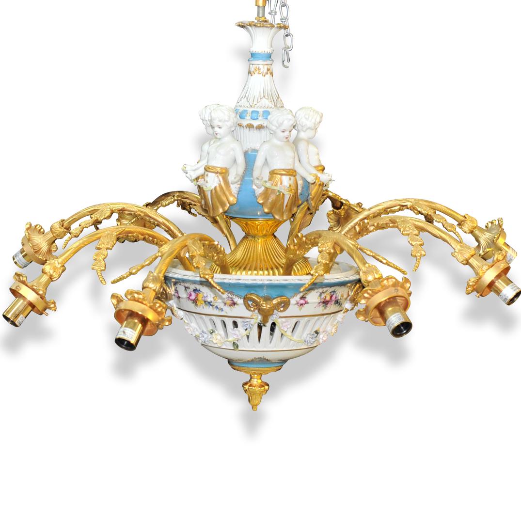 Sevres Style Gilt Bronze and Porcelain Figural: DESCRIPTION: A French Gilt & Sevres Style porcelain chandelier. Eight arm wired chandelier featuring double vasiform body in light blue and white porcelain ground with parcel gilt highlights. The uppe