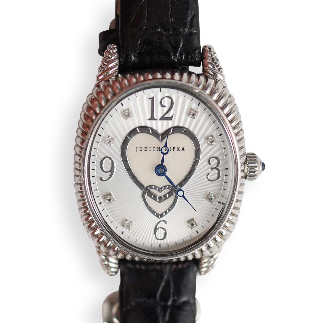 Judith Ripka Sterling Silver Watch: DESCRIPTION: A Judith Ripka watch composed of sterling silver case, oval dial, Quartz movement and black strap. Marked along the back "Sterling Silver case". Comes with original box and paper. CIRCA: 