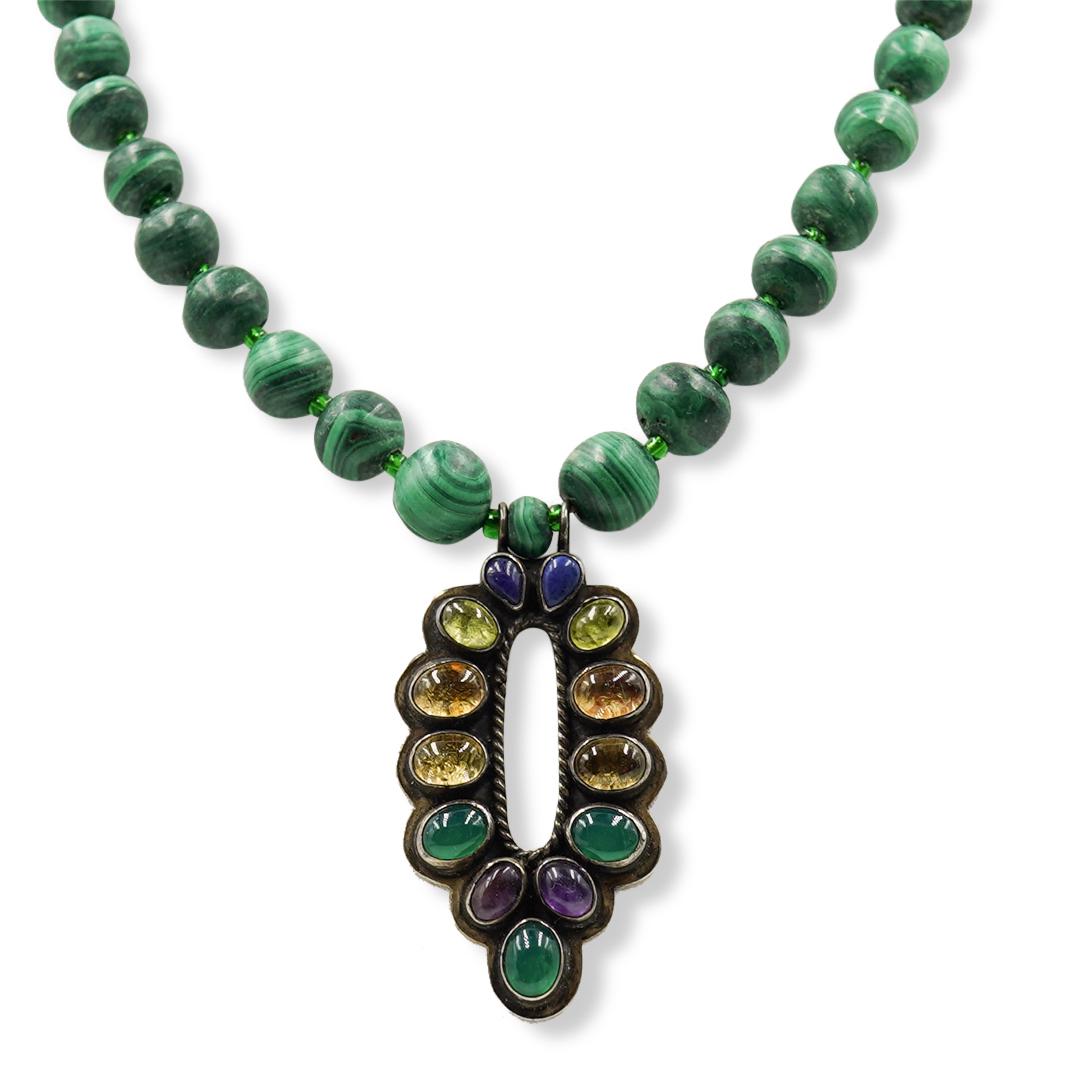 Nakai Sterling and Malachite Necklace: DESCRIPTION: A single layer Malachite necklace with sterling pendant decorated with various multi-colored semi precious stones, ending with an oval jade stone. Marked: "Sterling Nakai" Weight 58 grams