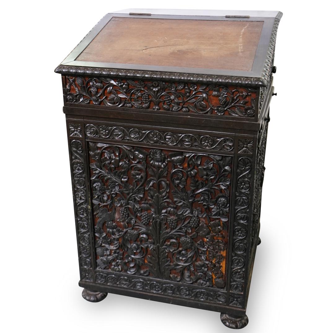 Antique Carved Wood Captains Desk: DESCRIPTION: An antique captains desk composed of intricately carved wood with floral, vine, and bird motifs. Top flips open revealing storage and four small drawers. Key turn lock mechanism unlocks h