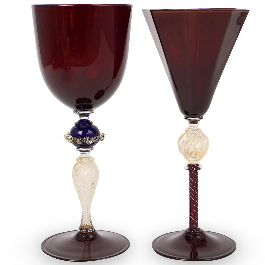 Pair Of Murano Wine Glasses: DESCRIPTION: A pair of Murano wine glasses with ruby coloring and semi gilt accented stems. Label attached at bottom "Made In Murano Italy" CIRCA: 20th Ct. ORIGIN: Italy DIMENSIONS: ( H: 9.75" x D: 4"