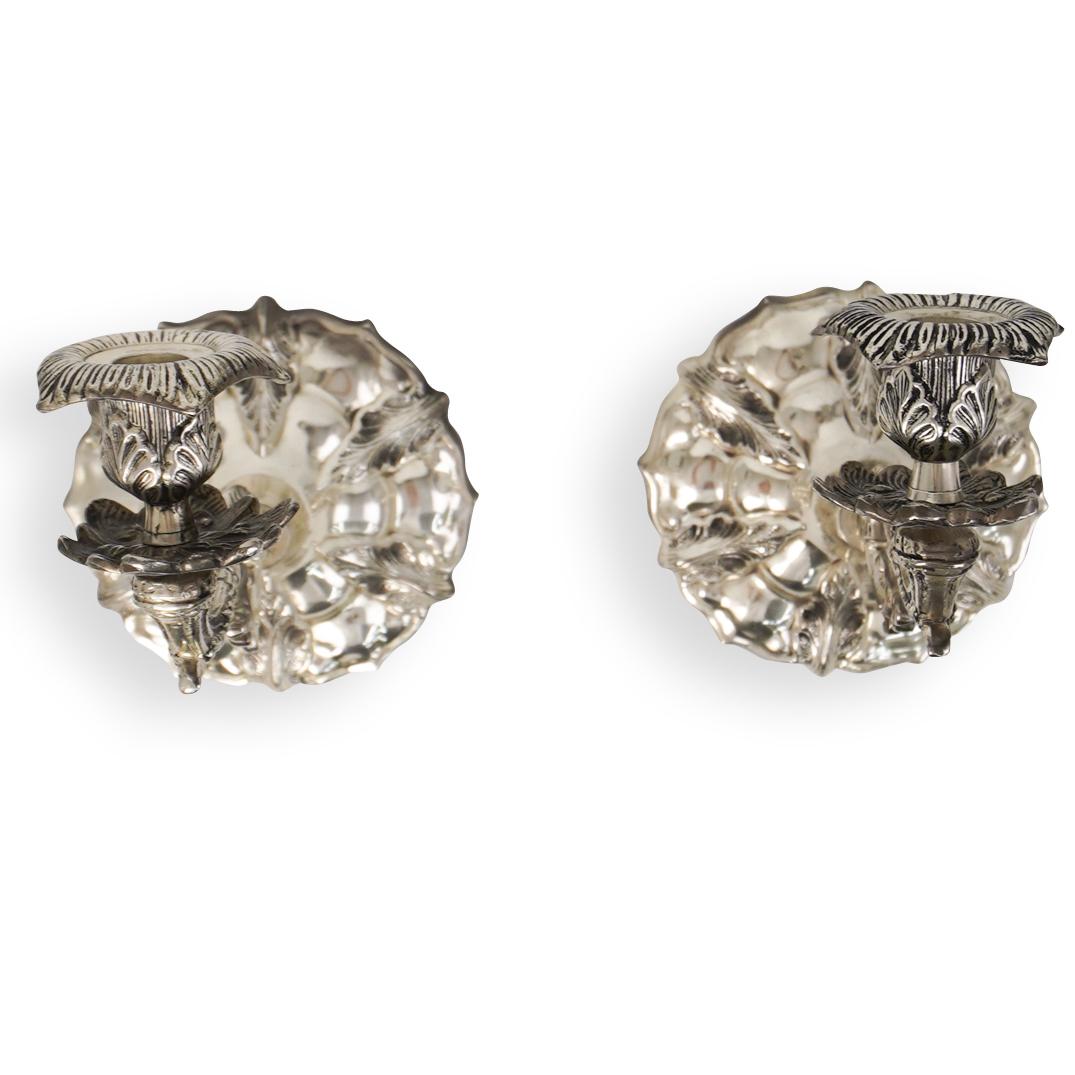 Pair Of Wall Mounted Silver Sconce: DESCRIPTION: A pair of wall mounted silver colored sconce with fitting for a single candle. CIRCA: 20th Ct. ORIGIN: Continental DIMENSIONS: H: 7" x L: 9" CONDITION: Great condition. See lot descriptio