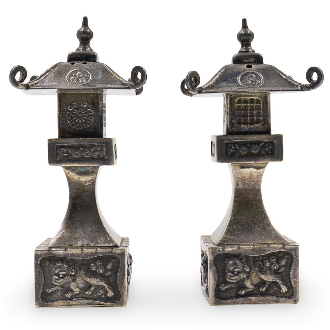 Vintage Chinoiserie Sterling Silver Salt Cellars: A pair of sterling silver salt cellars in chinoiserie motif. Marked on the bottom Sterling. Weigh a total of 57 grams CIRCA: Early 20th ORIGIN: Unknown DIMENSIONS: H:3" and 1.25" by 1.25" CONDITION: G