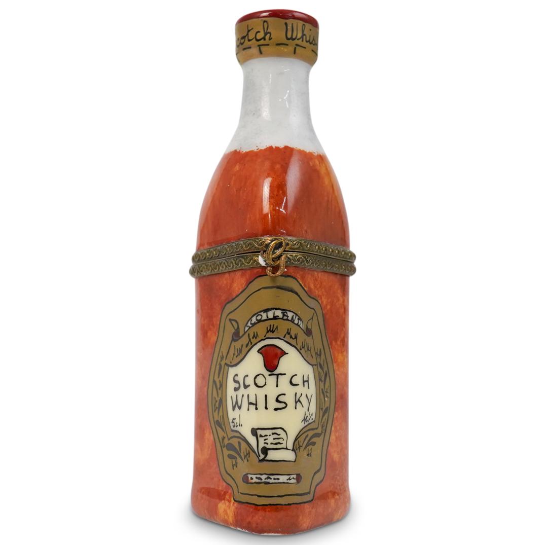 Limoges Scotch Whisky Pill Box: A Limoges hand painted scotch whisky pill box in a bottle form, marked "Peint Main, Limoges, France. CIRCA: 20th Ct. ORIGIN: France DIMENSIONS: H: 4" x D: 1.5" CONDITION: Great condition. See lot desc
