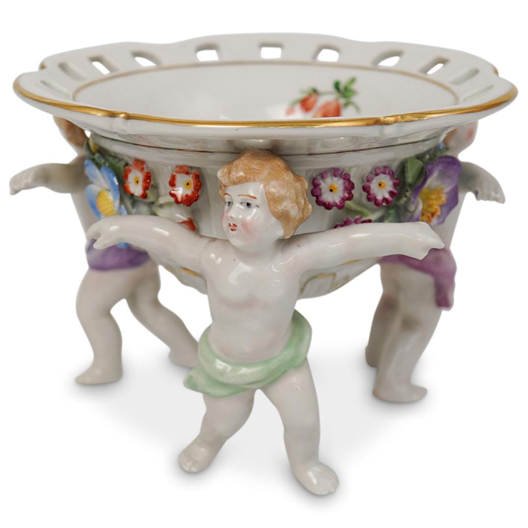 Von Schierholz Porcelain Candy Bowl: DESCRIPTION: Von Schierholz porcelain candy bowl adorned with floral motif around the whole body and three cherubs propping the bowl up. Marked "Van Shierholz" on the bottom.Ã‚ CIRCA: 20th CenturyO