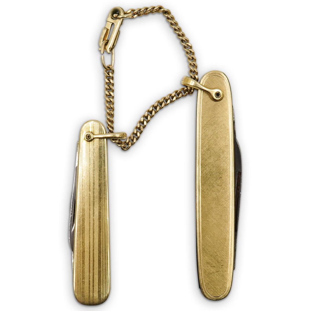 Vintage Gold Filled Pocket Knives: DESCRIPTION: A Pair of gold filled pocket knives linked together by a chain, features one from "Imperial" and the other from "Voos" each marked along the blade.CIRCA: Mid 20th Cent.ORIGIN: USADIMENSIO