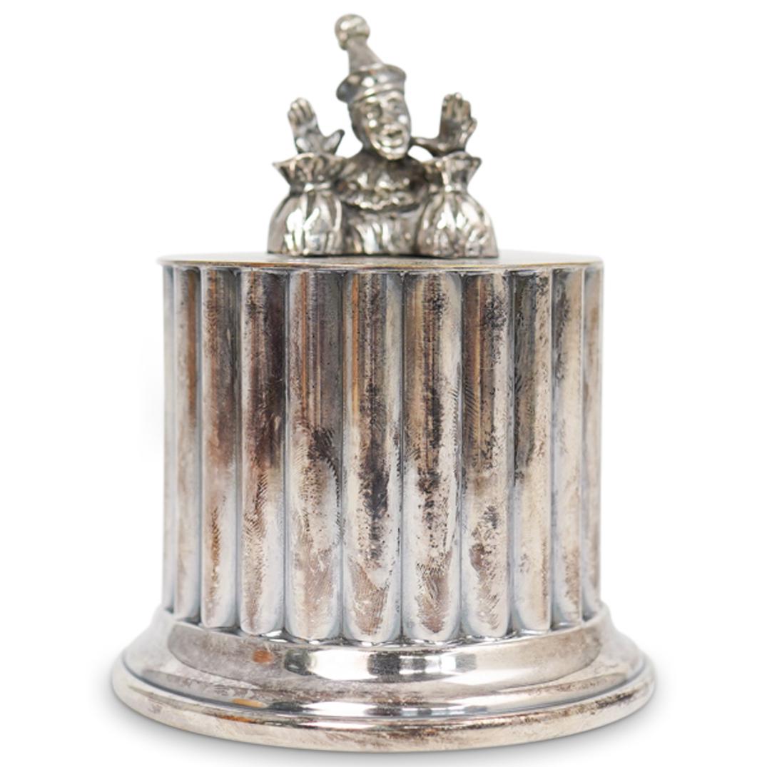 Reed and Barton Silver Plated Piggy Bank: DESCRIPTION: Reed and Barton silver plated piggy bank with a clown figurine at the top. Stamped "Reed and Barton"CIRCA: 20th CenturyORIGIN: USADIMENSIONS: L 3.0" x W 3.5"CONDITION: Great condition. Se
