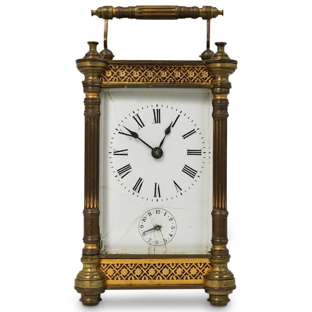 European Brass and Glass Carriage Clock: DESCRIPTION: A European Carriage glass composed of a brass frame encompassed by glass, featuring a porcelain dial. Comes with original key.CIRCA: Early 20th Cent.ORIGIN: EuropeanDIMENSIONS: H: 5.25" W
