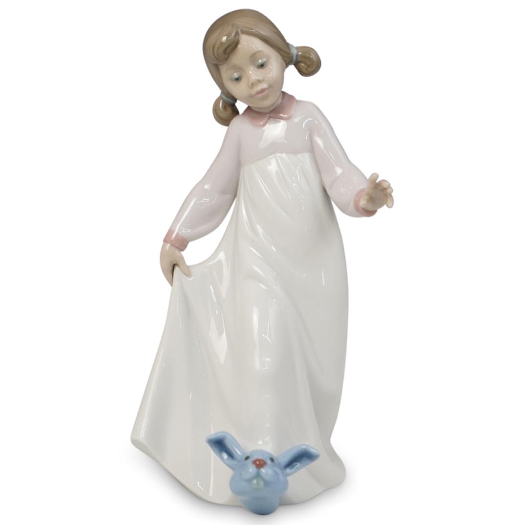 Lladro "Off To Bed" Porcelain: DESCRIPTION: Lladro "Off To Bed" #6421. Depicts a young girl in a nightgown and bunny slippers going off to bed. Stamped "Lladro" underneath. CIRCA: 20th Century ORIGIN: Spain DIMENSIONS: H 9.0" x W 3
