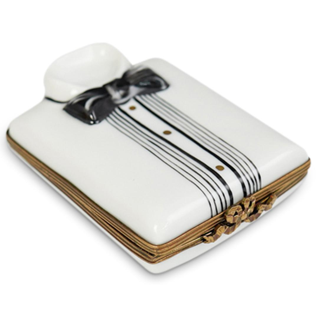 Limoges Porcelain Tuxedo Pill Box: DESCRIPTION: Limoges porcelain pill box depicting a tuxedo on the lid. Stamped "Limoges" on the bottom of the base CIRCA: 20th Century ORIGIN: France DIMENSIONS: L 3.5" x W 2.0" CONDITION: Great condi