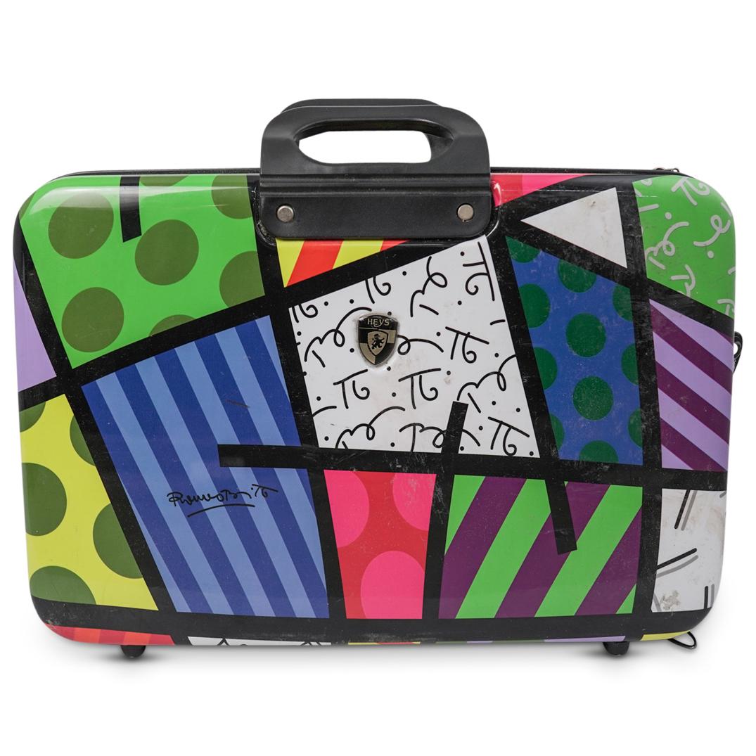 Britto Briefcase by Heys: DESCRIPTION: Britto Briefcase by Heys. Features a colorful rendering of Brittos classic design. Handles atop and a zipper along the center. Opens to reveal a blue spotted interior. CIRCA:20th Ct ORIGI