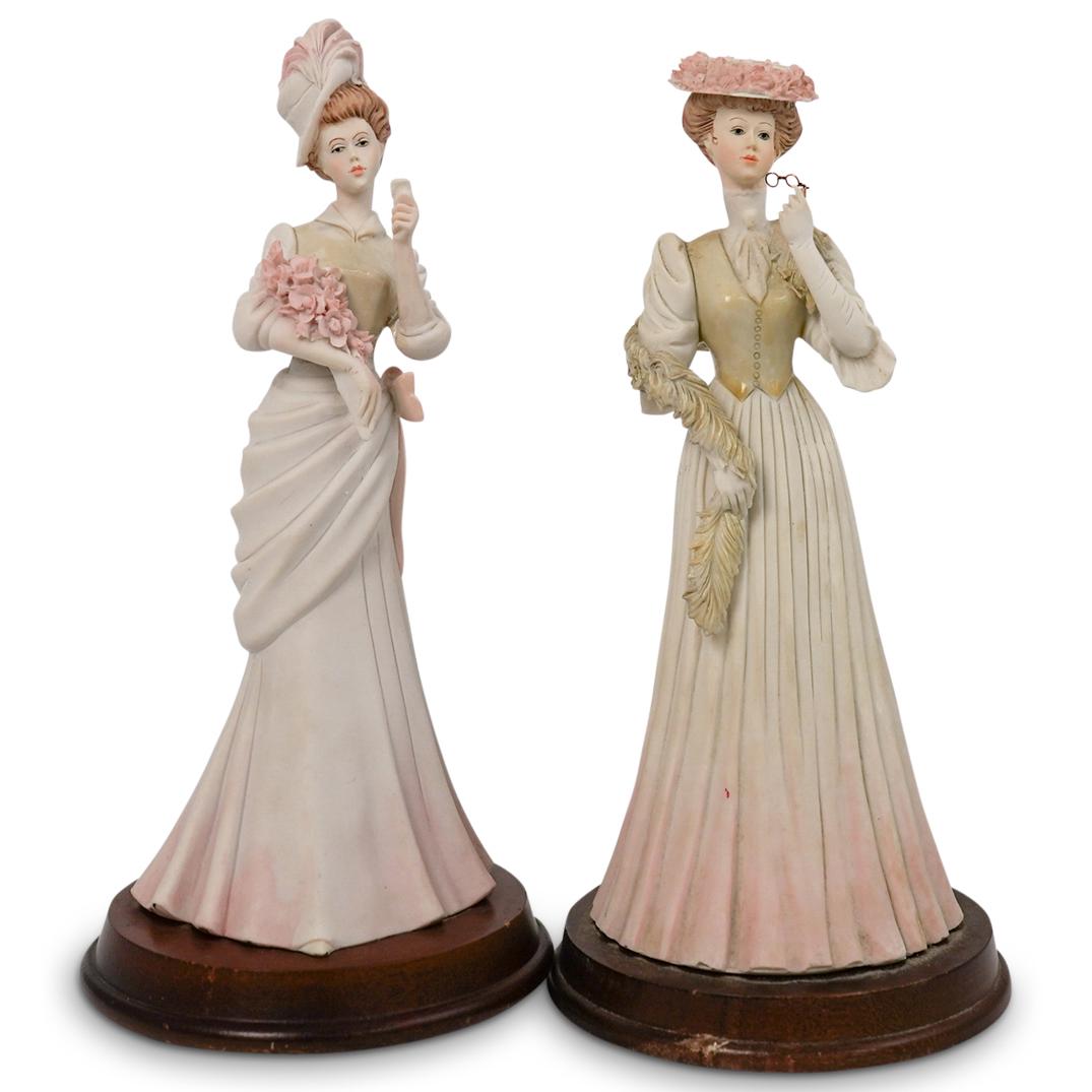 Pair of Pucci Arnart Porcelain Figurines: DESCRIPTION: Pair of Pucci Arnart porcelain figurines includes: (1) Pucci Arnart porcelain figurine depicting a woman holding her glasses, while in a dress and scarf wrapped around her. Signed "Pucci 