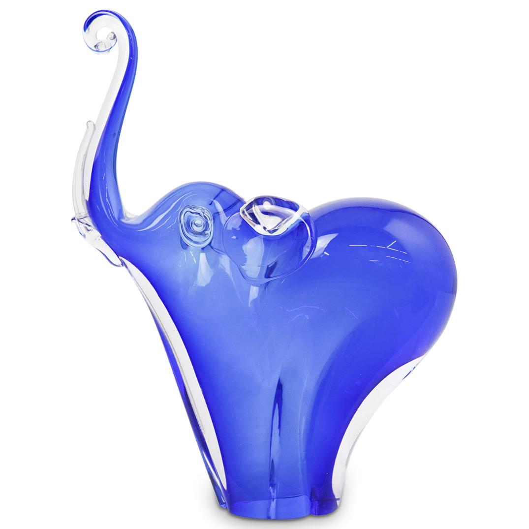 Blue Glass Elephant Statue: DESCRIPTION: A blue glass elephant motif statue. Features an elephant with raised trunk and tusks finished in a deep vibrant blue color tone. CIRCA: 20th Ct. ORIGIN: Italy DIMENSIONS: H: 12" x W: 3.5"