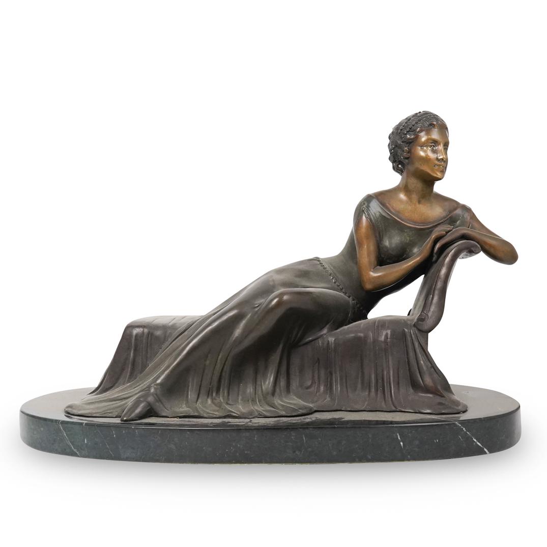 Laying Bronze and Marble Statue: DESCRIPTION: A Bronze statue depicts a woman laying across a daybed, completed in a dark brown patina. Fitted atop a green marble base. Unmarked. CIRCA: 20th Cent. ORIGIN: USA DIMENSIONS: H: 13.5" W: 