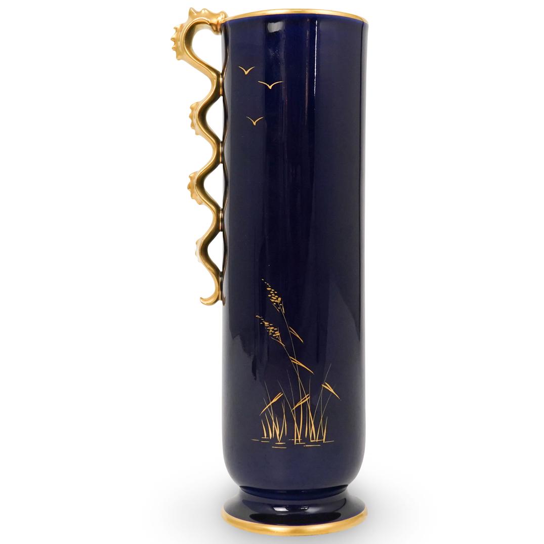 Rosenthal Kunstabteilung Porcelain Vase: DESCRIPTION: A Rosenthal Kunstabteilung porcelain vase. Features a tall cobalt blue cylindrical form vase with gilt dragon motif handle. Further decorated with flying duck and grass accented motifs al