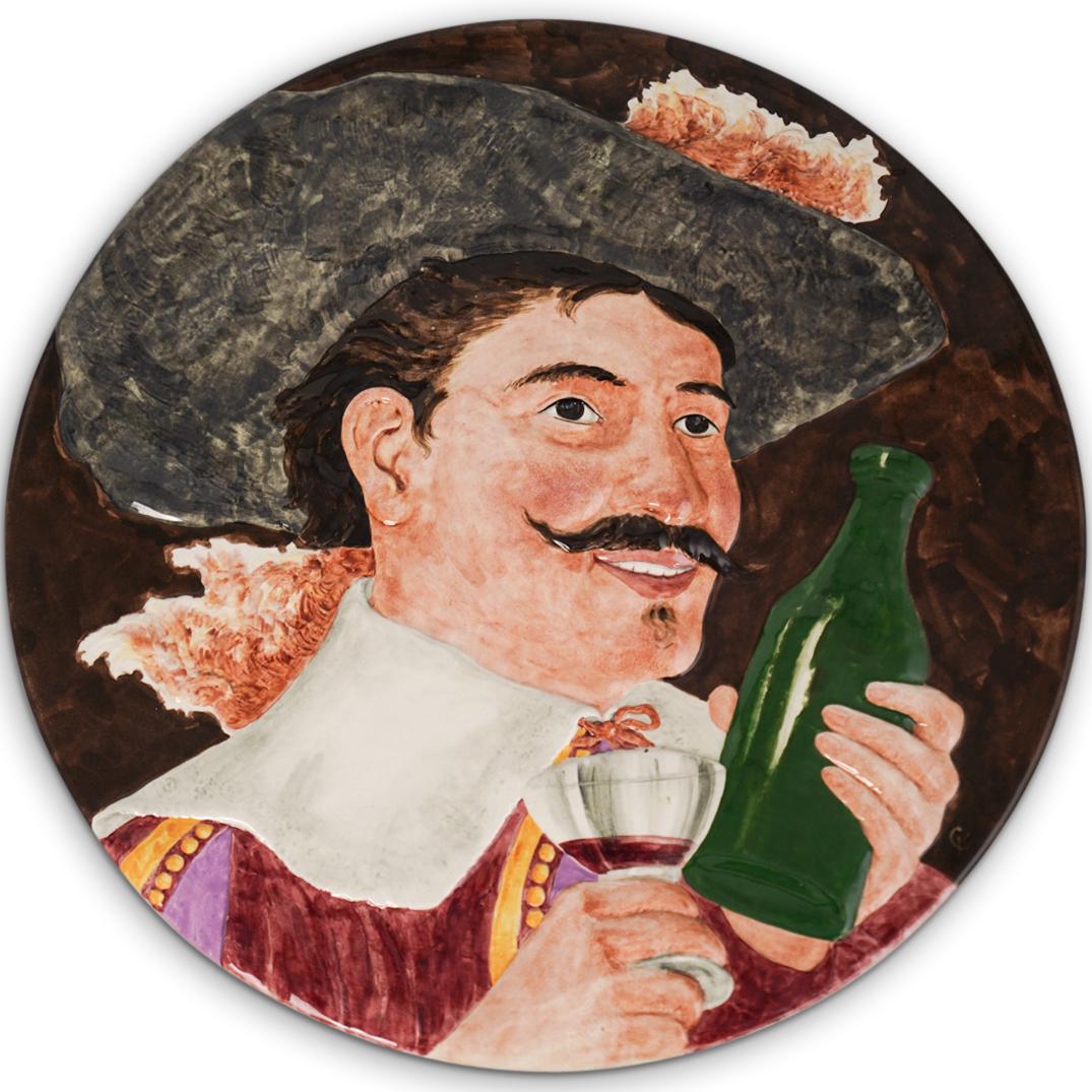 Sarreguemines Ceramic Charger: DESCRIPTION: A Large Sarreguemines ceramic charger depicts figure drinking a bottle, impressed along the back Sarreguemines and #. CIRCA: Early-Mid 20th Cent. ORIGIN: France DIMENSIONS: Diameter: 20.5