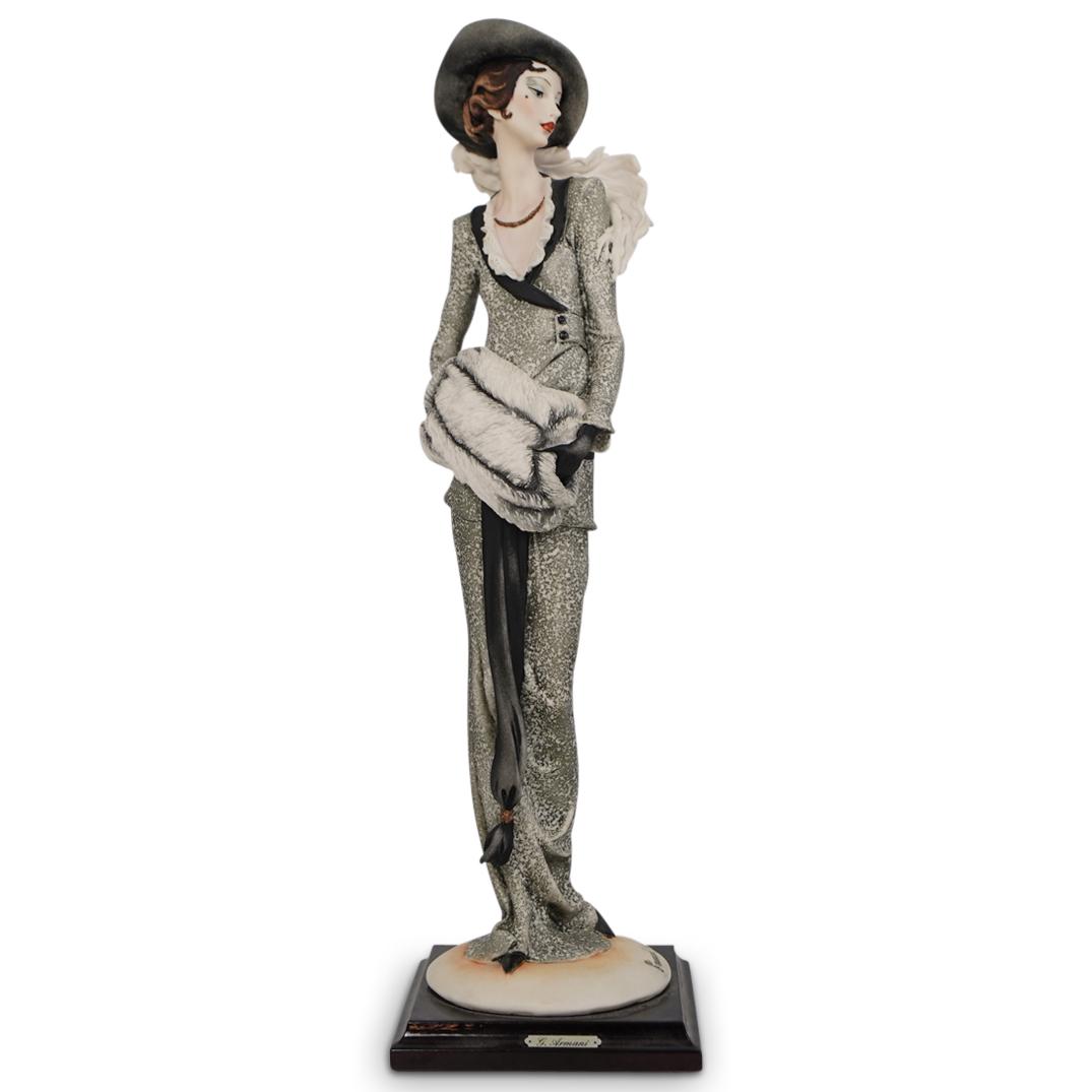 Limited Edition Giuseppe Armani "Lady with Muff": DESCRIPTION: Limited edition Giuseppe Armani "Lady with Muff" porcelain figurine. Depicts a woman posing in winter attire while warming her hands with a muff. Marked "G Armani" "Limited Edition 505/50