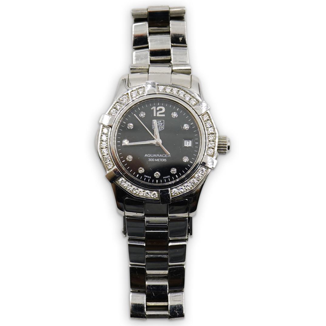 Tag Heuer "AQUARACER" Diamond Watch: DESCRIPTION: A stainless steel Tag Heuer "Aquaracer" ladies diamond watch with a quartz black dial and diamond factory bezel (27MM). Reference number "WAF 141D" marked on the back. CIRCA: Probably 199