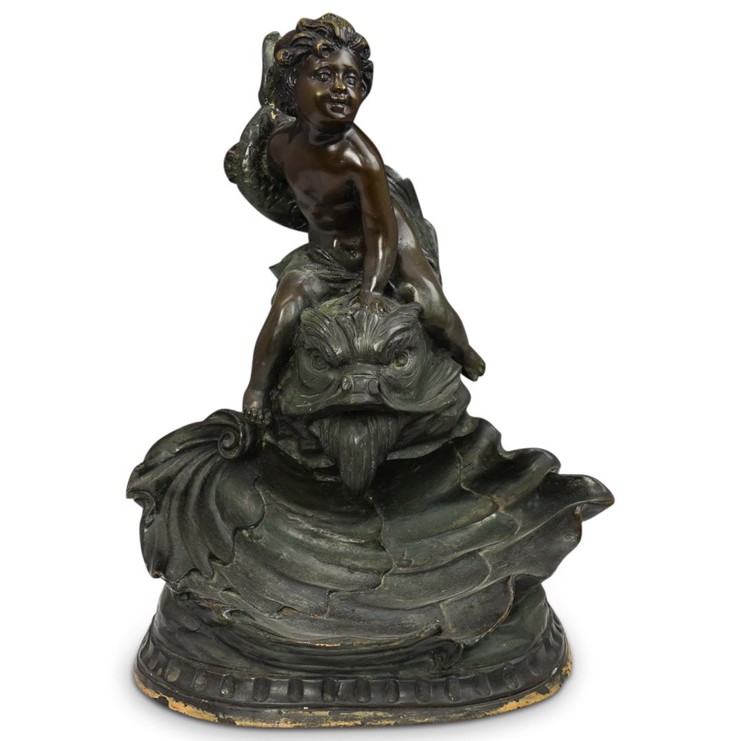 Att. Sylvain Kinsberg Mixed Metal Sculpture: DESCRIPTION: Att. Sylvain Kinsberg Mixed Metal Sculpture. Features a young male figure sitting on top of a dolphin. The base is further embellished with waves and floral motifs. Signed "KNSBURGER" CIR