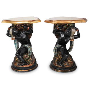 Antique Polychrome Blackamoor Pedestals: DESCRIPTION: Antique Polychrome wood Blackamoor Pedestals. Featuring seated figures with crossed legs holding a three sided tray above their heads. Finished with ebonized overall hue along with age