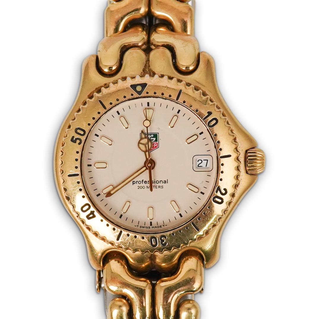 Tag Heuer 34MM Professional Watch: DESCRIPTION:Tag Heuer "Professional 200 Meters" watch in a gold tone over stainless steel band and bracelet with a 34MM dial. Reference number WG1130-0. Watch is used and some of the gold is fading. C