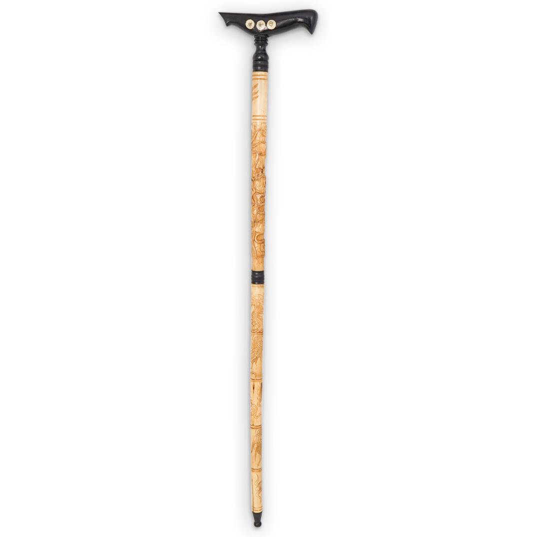 Antique Chinese Carved Bone Cane: DESCRIPTION: An antique Chinese hand carved bone cane. Features figural wise man, dragon, and cloud motifs throughout. Fitted with a carved black lacquer wood handle. CIRCA: 19th Cent. ORIGIN: China D