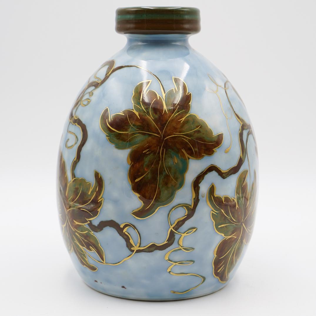 Camille Tharaud (French 1878-1956) Limoges Vase: DESCRIPTION: A beautiful Limoges porcelain vase by Camille Tharaud. Hand painted through on a light blue ground color with multi color leaves and a gold overlay. Marked on the bottom "tharaud" and "Li